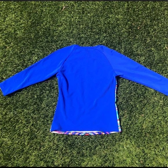 Mara Hoffman rash guard with pink ganesh against a pool blue background